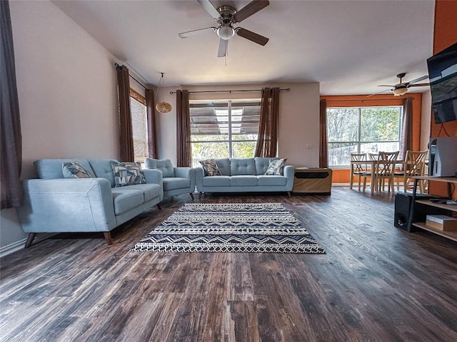 living room featuring plenty of natural light, dark wood-type flooring, and ceiling fan