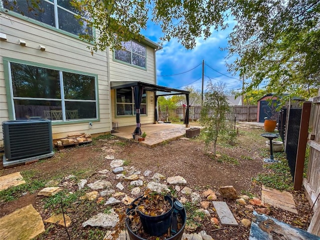 view of yard with central AC unit, a shed, and a patio