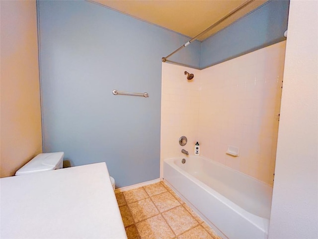 bathroom with tile patterned floors, tiled shower / bath combo, and toilet