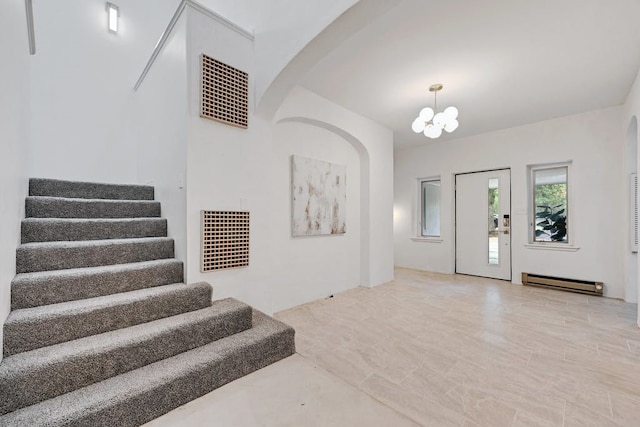 entrance foyer with a baseboard radiator and a notable chandelier