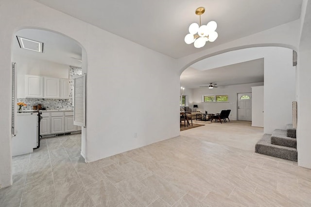 interior space featuring ceiling fan with notable chandelier