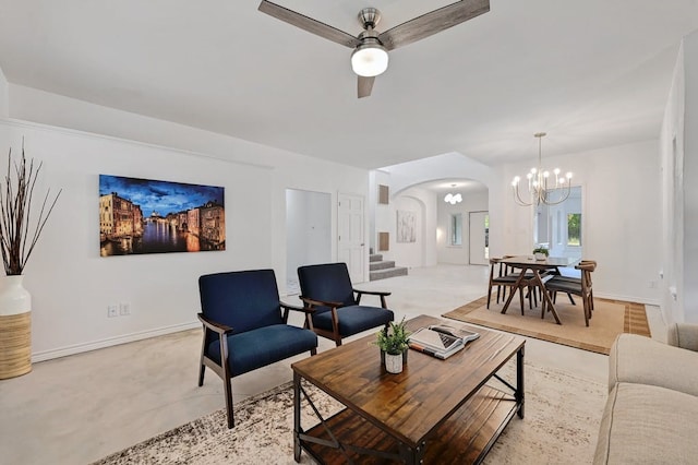 living room featuring ceiling fan with notable chandelier