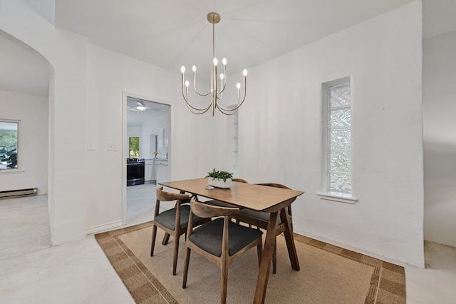 dining space featuring baseboard heating and a chandelier