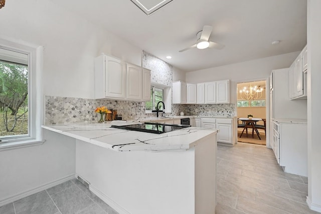 kitchen featuring kitchen peninsula, white cabinets, and plenty of natural light