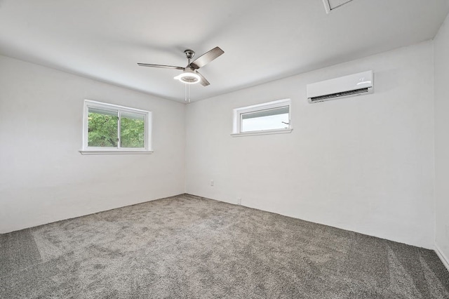 carpeted spare room featuring a wall mounted AC and ceiling fan