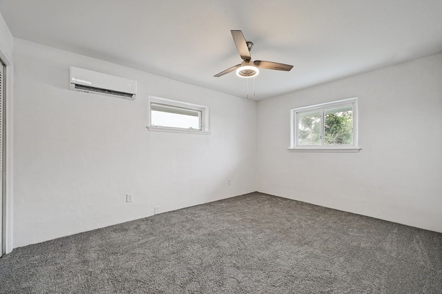 carpeted spare room with ceiling fan and a wall mounted air conditioner