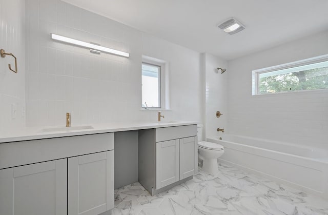 full bathroom with vanity, a healthy amount of sunlight, tiled shower / bath combo, and toilet