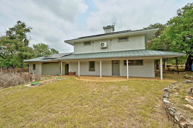 back of house with solar panels and a yard