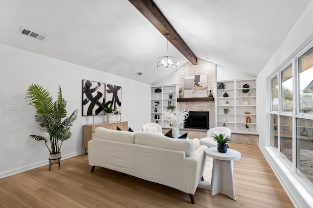 living room featuring vaulted ceiling with beams, a fireplace, a chandelier, and light hardwood / wood-style floors