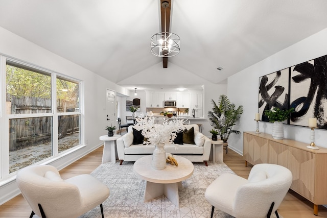 living room featuring lofted ceiling with beams, a chandelier, and light hardwood / wood-style flooring