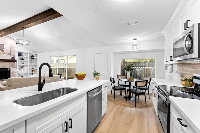 kitchen featuring sink, decorative light fixtures, white cabinets, and appliances with stainless steel finishes