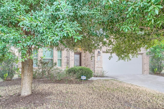 view of property hidden behind natural elements featuring a garage