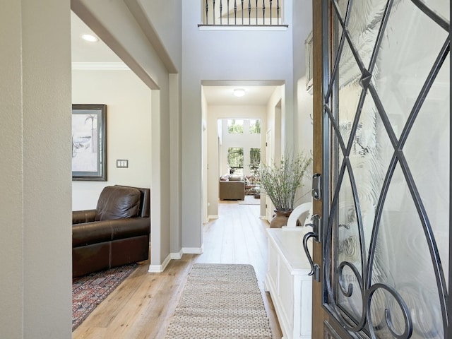 entrance foyer featuring crown molding and light hardwood / wood-style flooring