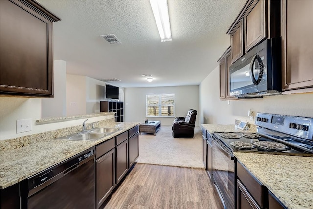 kitchen featuring dark brown cabinetry, sink, a textured ceiling, black appliances, and light wood-type flooring