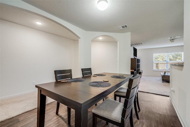 dining room featuring hardwood / wood-style floors and a textured ceiling