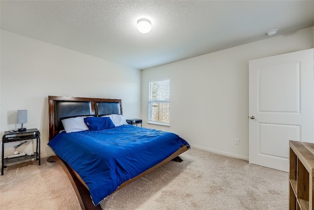 bedroom with light carpet and a textured ceiling