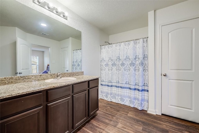 bathroom featuring vanity, wood-type flooring, and a textured ceiling