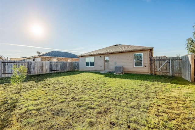 back of house featuring a yard and central AC