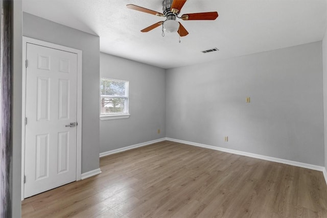 spare room featuring light wood-type flooring and ceiling fan