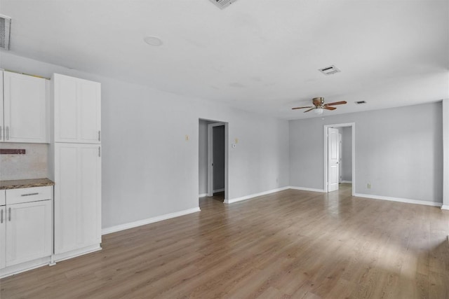 unfurnished living room with ceiling fan and wood-type flooring