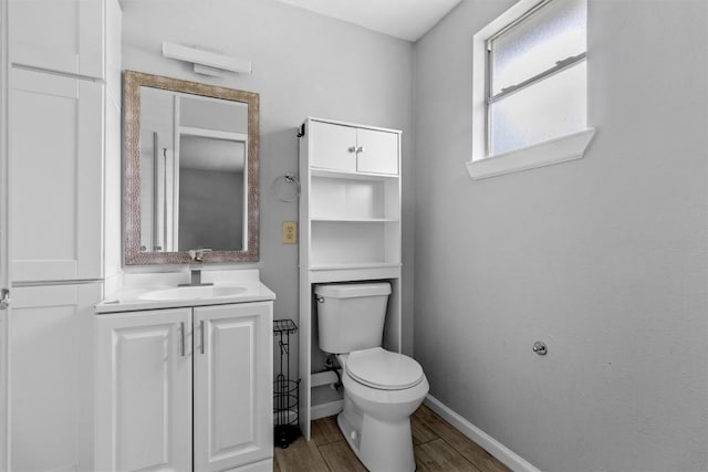 bathroom featuring toilet, vanity, and hardwood / wood-style flooring