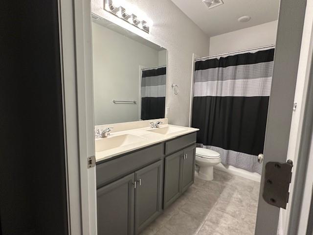 bathroom with a shower with curtain, vanity, and toilet