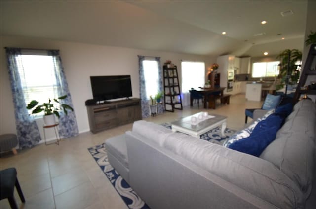 living room featuring light tile patterned floors, vaulted ceiling, and a wealth of natural light