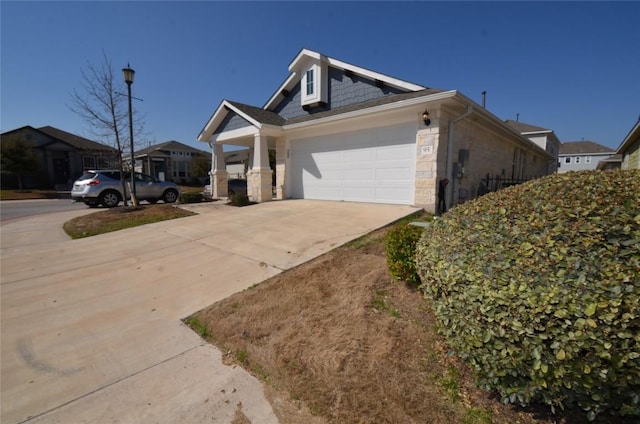 view of front of property with concrete driveway, a garage, and stone siding