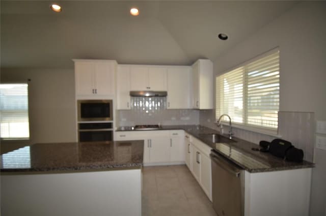 kitchen featuring a kitchen island, under cabinet range hood, white cabinets, stainless steel appliances, and a sink