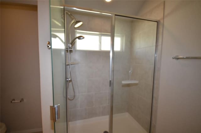 full bathroom with a stall shower and toilet