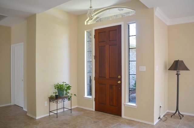 entrance foyer with light tile patterned floors, crown molding, and an inviting chandelier