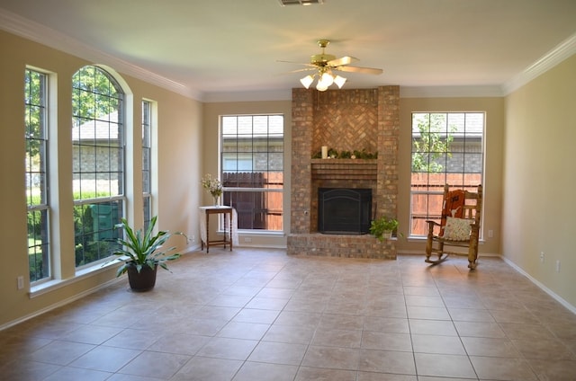 unfurnished room with ceiling fan, light tile patterned floors, crown molding, and a brick fireplace