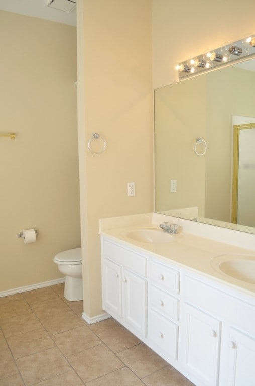 bathroom with tile patterned flooring, vanity, a shower with door, and toilet