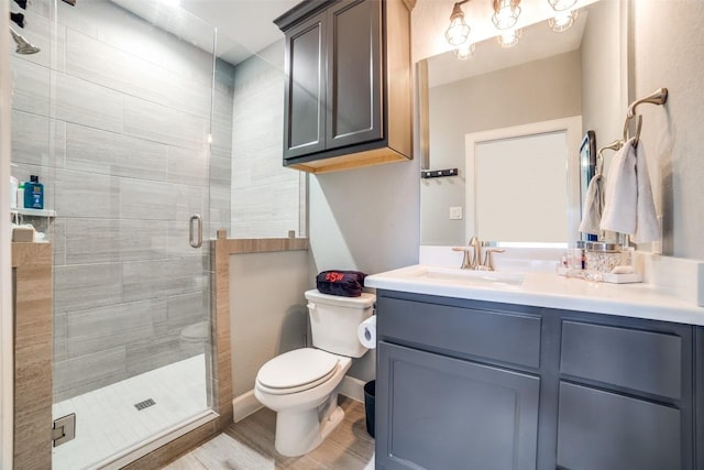 bathroom with vanity, wood-type flooring, a shower with door, and toilet