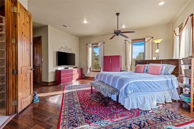 bedroom with dark wood-type flooring, ceiling fan, and multiple windows