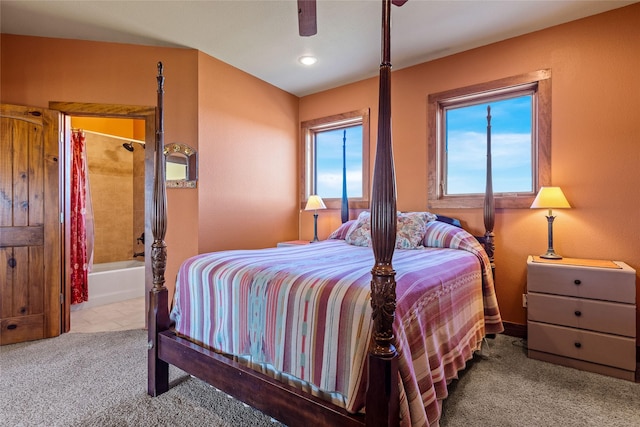 bedroom featuring connected bathroom, light carpet, and ceiling fan