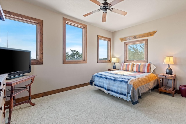 carpeted bedroom featuring multiple windows and ceiling fan