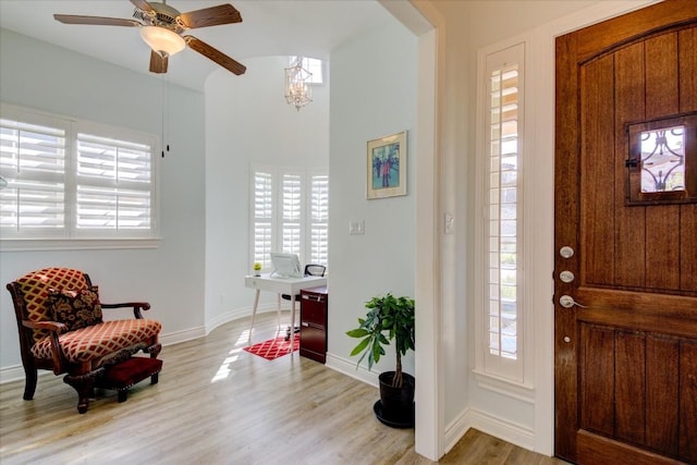 foyer entrance with ceiling fan and light wood-type flooring