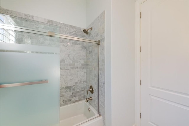 bathroom with combined bath / shower with glass door