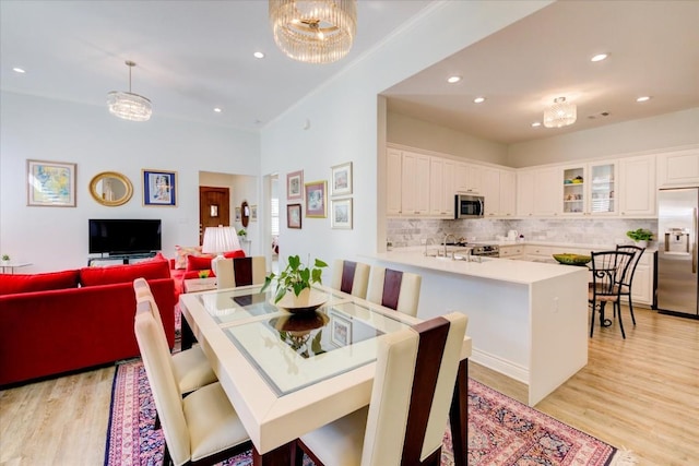 dining area featuring a chandelier, light hardwood / wood-style flooring, and sink