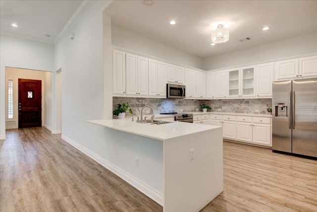 kitchen featuring decorative backsplash, stainless steel appliances, white cabinetry, and sink