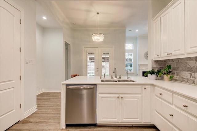 kitchen featuring pendant lighting, white cabinets, sink, stainless steel dishwasher, and tasteful backsplash