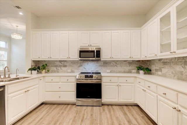 kitchen featuring pendant lighting, sink, white cabinets, and stainless steel appliances