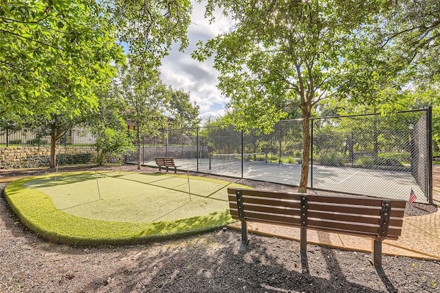 view of home's community featuring tennis court