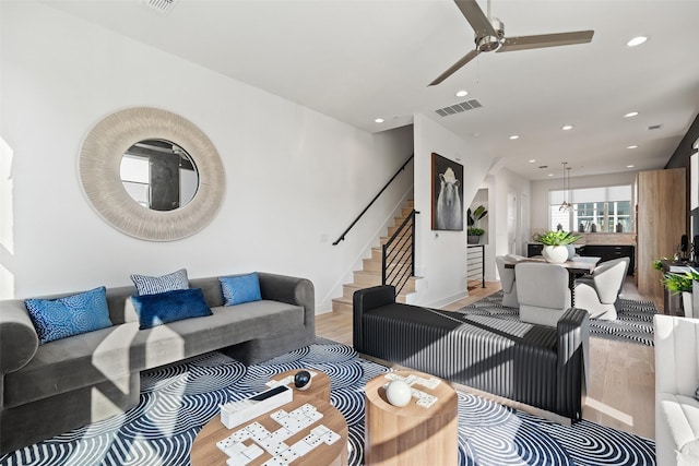 living room with ceiling fan and light wood-type flooring