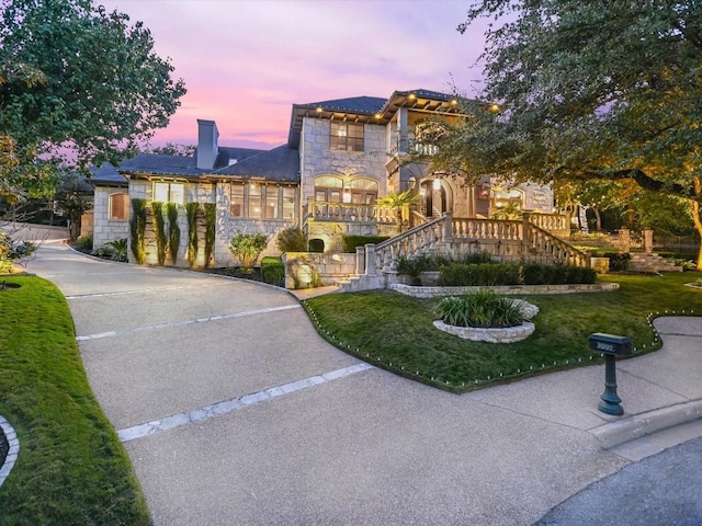 3001 Pescadero Cv, Austin, TX 78746 - view of front facade with a chimney, a front yard, stone siding, and stairway