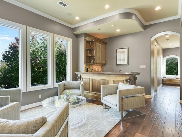 living area with dark hardwood / wood-style floors and ornamental molding