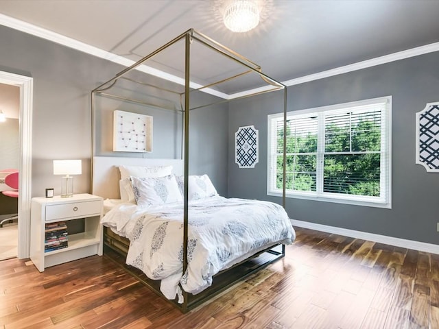 bedroom with dark hardwood / wood-style flooring and ornamental molding