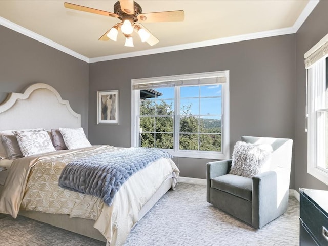 carpeted bedroom featuring ceiling fan and crown molding