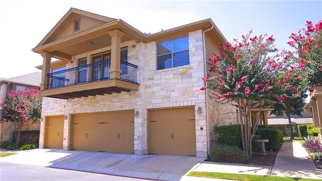 view of front of property featuring a balcony and a garage